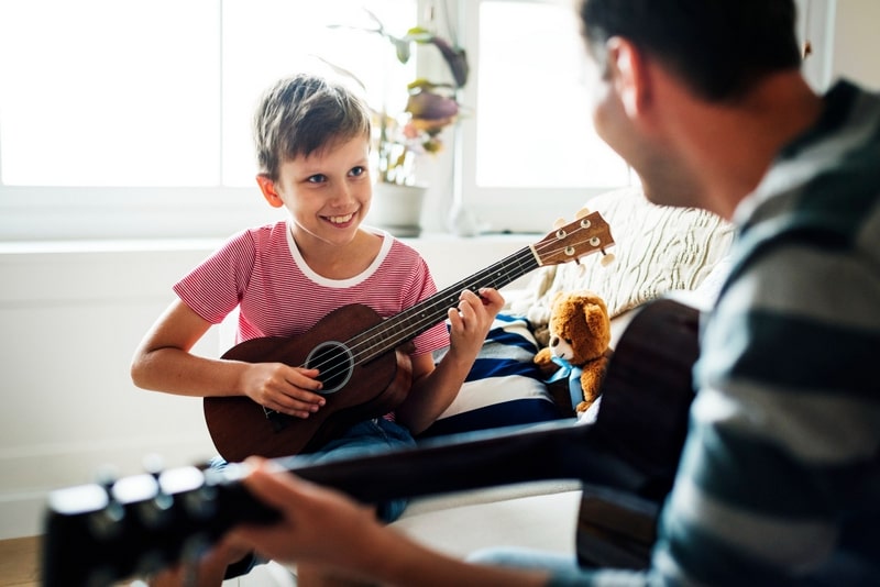 young boy playing guitar min - موسیقی کودکان